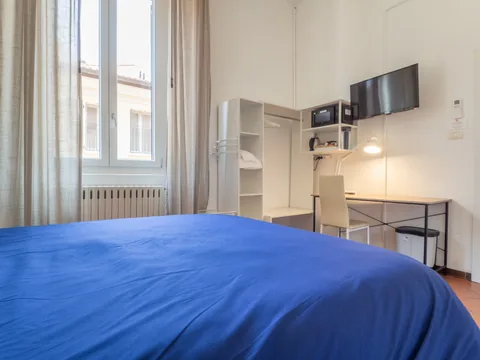 Bedroom with a blue bedspread and desk area