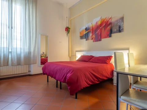 Bedroom with a red bedspread and desk