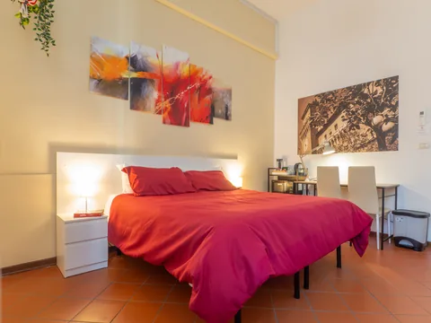 Bedroom with a red bed and bedside tables