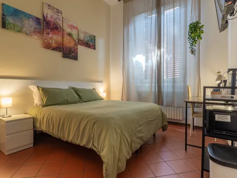 Bedroom with a green bedspread and welcome tray