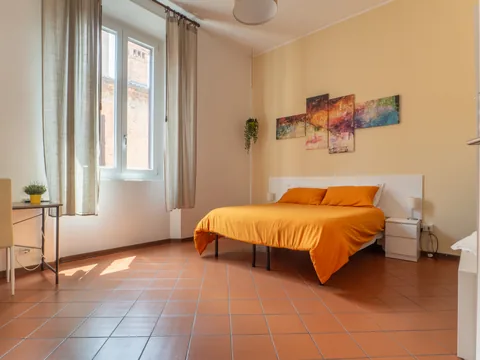 Bedroom with an orange bed and window