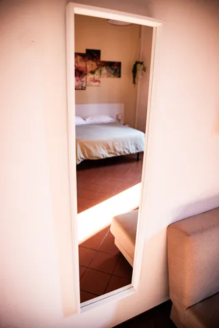 Mirror reflecting the bedroom
